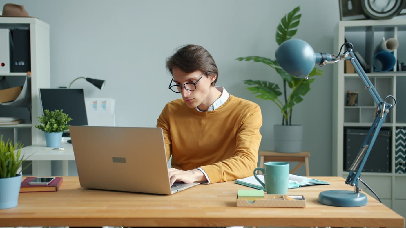 Ondernemer aan een licht thuisbureau met laptop