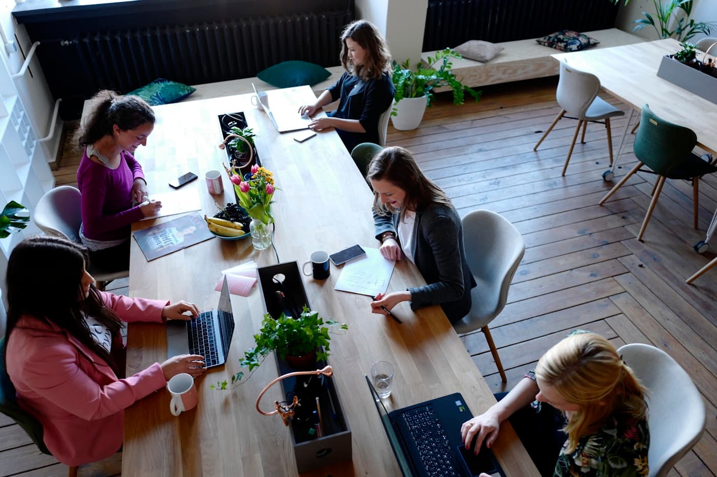 Klein team overlegt aan een lichte houten tafel in een ruime werkruimte